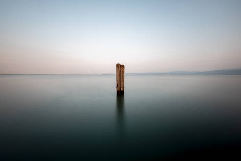 Italy, Veneto, Wooden pole in Lake Garda - DAWF01052