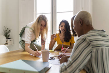 Businesswomen having a meeting and taking notes in office - AFVF04719