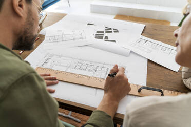 Crop view of two architects working together at desk in office - AFVF04778