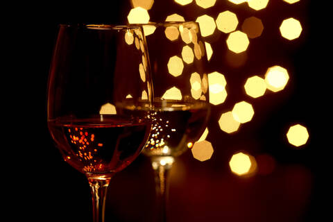 Germany, Glasses of wine with Christmas lights in background stock photo