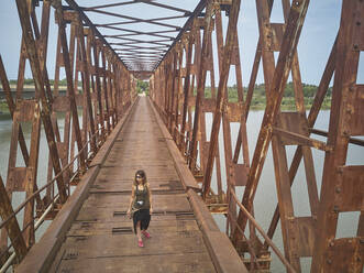 Benin, Grand Popo, Touristin über rostige Eisenbrücke - VEGF01233