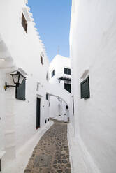 Spanien, Menorca, Binibeca, Weiß getünchte Häuser und enge Gasse - RAEF02309