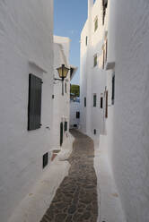 Spain, Menorca, Binibeca, Whitewashed houses and narrow alley - RAEF02310