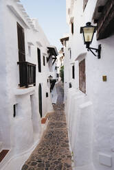 Spain, Menorca, Binibeca, Whitewashed houses and narrow alley - RAEF02312