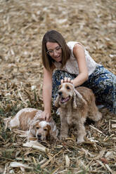 Frau auf einem Feld mit ihren Hunden - MAUF03190