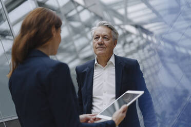 Businessman and businesswoman with tablet in modern office building - JOSF04161