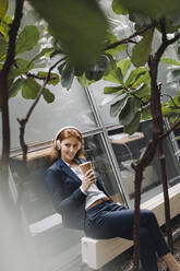 Businesswoman having a break in a modern office building - JOSF04183