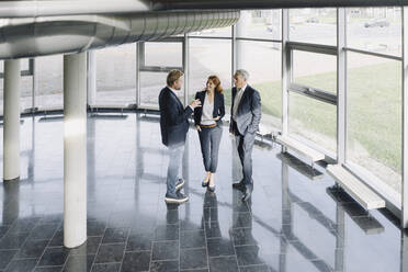 Business people talking at the window in modern office building - JOSF04207