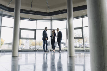 Business people talking at the window in modern office building - JOSF04208