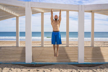 Sportler beim Training am Strand, Klimmzug - DLTSF00381