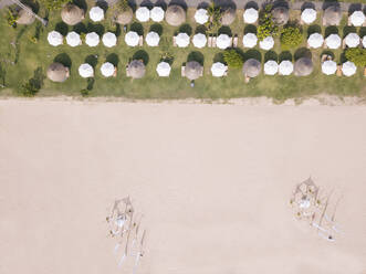 Indonesien, Bali, Nusa Dua, Luftaufnahme von Reihen von Sonnenschirmen am Strand - KNTF03960