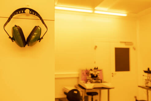 Ohrenschützer in einem Labor bei künstlichem gelbem Licht - AHSF01725