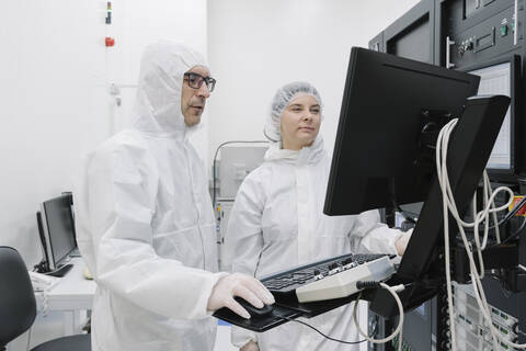 Zwei Wissenschaftler benutzen einen Computer im Labor des Wissenschaftszentrums, lizenzfreies Stockfoto