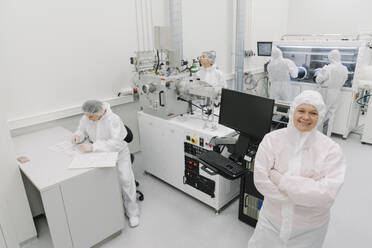 Porträt eines lächelnden Wissenschaftlers mit Kollegen im Labor - AHSF01781