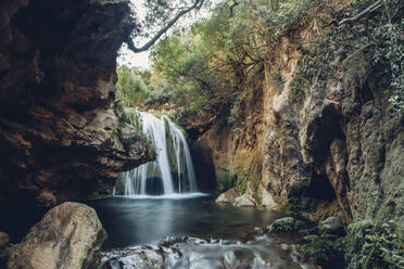 Malerischer Blick auf einen Wasserfall über Felsformationen im Wald - CAVF72503