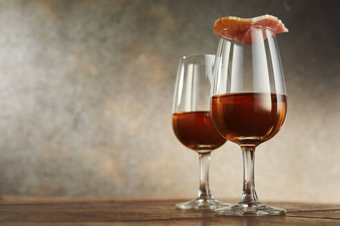 Studio shot of two glasses of traditional Spanish sherry, covered with ham - DREF00005