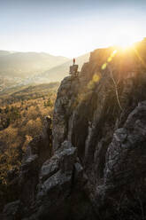 Man standing on rock needle at sunset at Battert rock, Baden-Baden, Germany - MSUF00112