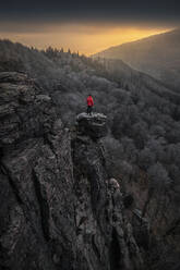 Mann stehend auf Felsnadel bei Sonnenaufgang am Battertfelsen, Baden-Baden, Deutschland - MSUF00116