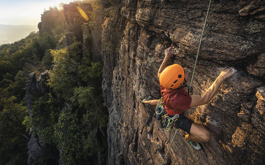 Mann klettert auf den Battert-Felsen bei Sonnenuntergang, Baden-Baden, Deutschland - MSUF00117