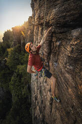 Mann klettert am Battert-Felsen bei Sonnenuntergang, Baden-Baden, Deutschland - MSUF00118