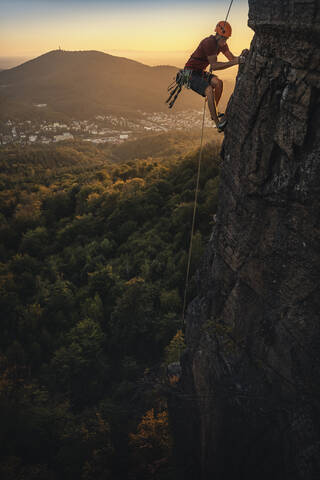 Mann klettert am Battert-Felsen bei Sonnenuntergang, Baden-Baden, Deutschland, lizenzfreies Stockfoto
