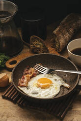 Russia, Saint Petersburg, Fried egg and bacon on frying pan - VPIF01900