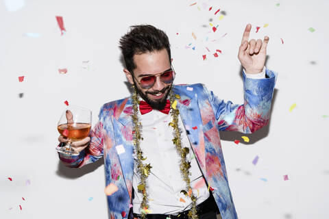 Cool and stylish man wearing a colorful suit and sunglasses dancing at a party stock photo