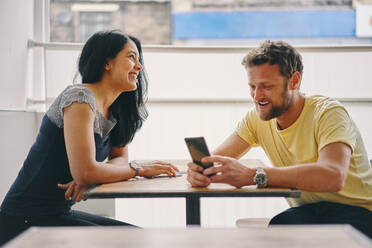 Paar im Gespräch und mit Smartphone im Restaurant - CUF54408