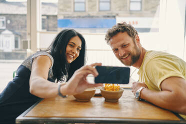 Couple taking selfie in restaurant - CUF54411