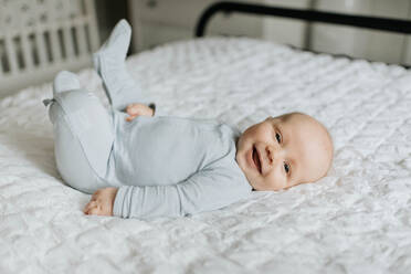 Lächelnder kleiner Junge im Bett - ISF23504
