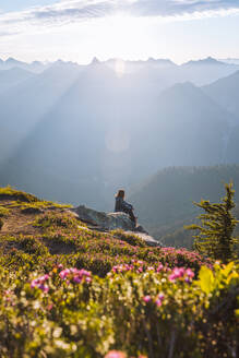 Wanderin genießt die Sonne auf dem Gipfel, Winchester Mountain, North Cascades, Washington - ISF23516