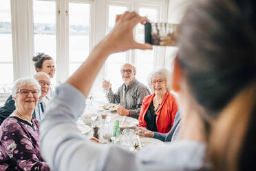 Besitzer klickt auf Foto von älteren Freunden, die im Restaurant sitzen - MASF16037