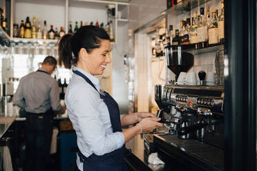 Lächelnde Barista mit Kaffeemaschine im Restaurant - MASF16058