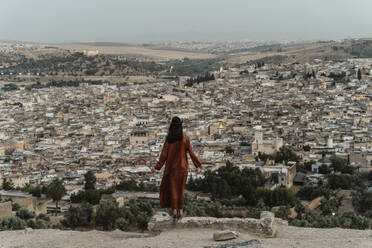 Rückenansicht einer Frau, die den Blick auf die Stadt am Abend genießt, Fez, Marokko - AFVF04812
