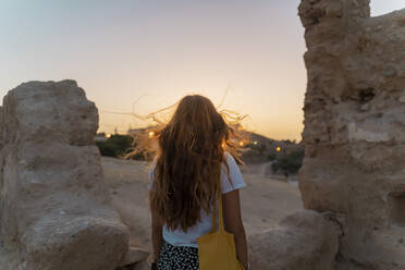 Rückenansicht einer rothaarigen Frau bei Sonnenuntergang, Fez, Marokko - AFVF04814