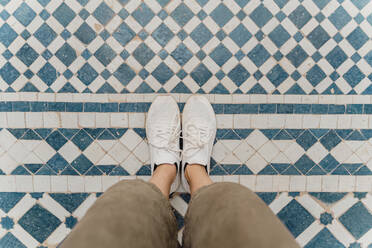 Woman's feet standing on traditionally tiled floor, Fez, Morocco - AFVF04829