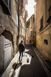 Frankreich Provence, Aix-en-Provence, Frau mit Hund auf der Straße - MSUF00138