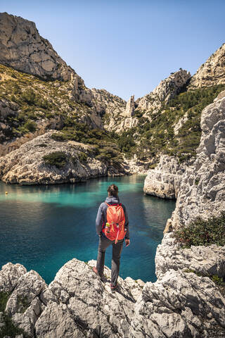 Frankreich, Cote d'Azur, Nationalpark Calanques, Frau mit Rucksack, Blick auf Kreidefelsen und Buchten, lizenzfreies Stockfoto