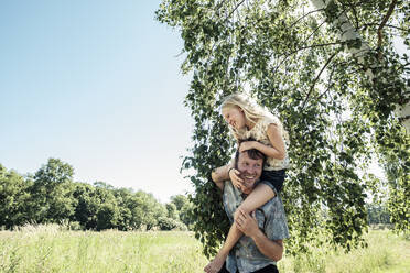 Happy father carrying daughter piggyback - WFF00227