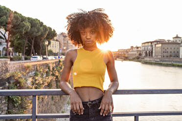 Porträt einer jungen Frau auf einer Brücke über den Fluss Arno bei Sonnenuntergang, Florenz, Italien - FBAF01173