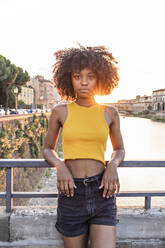 Porträt einer jungen Frau auf einer Brücke über den Fluss Arno bei Sonnenuntergang, Florenz, Italien - FBAF01174