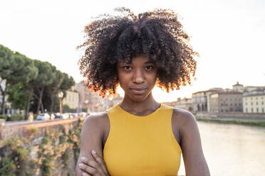 Porträt einer selbstbewussten jungen Frau am Fluss Arno bei Sonnenuntergang, Florenz, Italien - FBAF01176