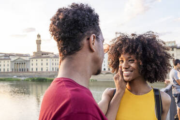 Glückliches junges Touristenpaar am Fluss Arno bei Sonnenuntergang, Florenz, Italien - FBAF01181