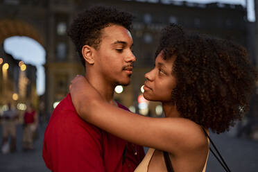 Affectionate young tourist couple in the city at dusk, Florence, Italy - FBAF01191