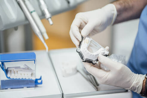 Close-up of dentist working on dentures - OCMF00969