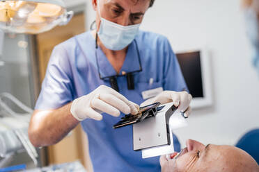 Close-up of dentist taking photo of dentures with special photographic apparatus - OCMF00976