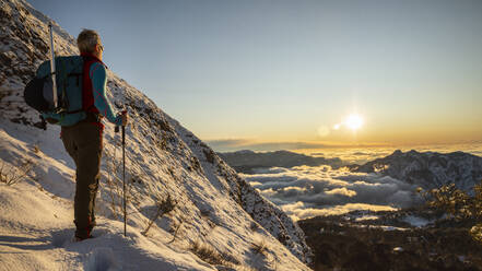 Bergsteiger am Berghang bei Sonnenaufgang, Orobie Alpen, Lecco, Italien - MCVF00161