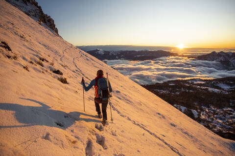 Mountaineer on the mountainside during sunrise, Orobie Alps, Lecco, Italy stock photo
