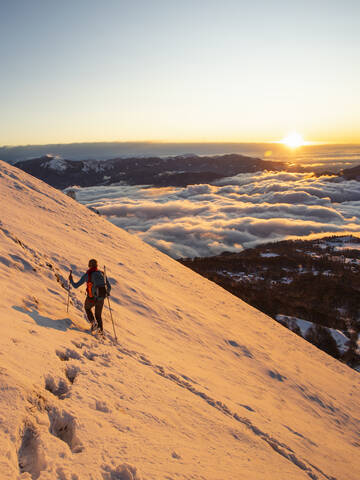 Bergsteiger am Berghang bei Sonnenaufgang, Orobie Alpen, Lecco, Italien, lizenzfreies Stockfoto