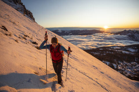 Bergsteiger am Berghang bei Sonnenaufgang, Orobie Alpen, Lecco, Italien, lizenzfreies Stockfoto